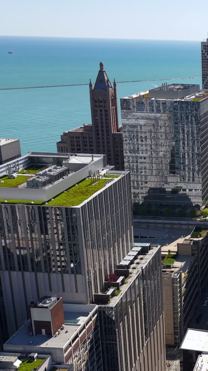 Imagem vertical de drone de torres antigas e novas do centro de Chicago, EUA, com o Lago Michigan ao fundo.