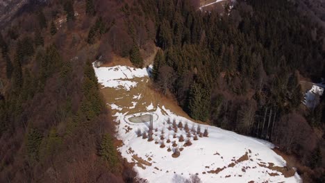 Aerial-View-Of-Snow-Covered-Hillside-With-Orobie-Cattedrale,-Parallax-Shot-To-Reveal-Snow-Capped-Mountains-And-Valley-Forest