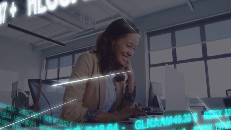Woman at desk on call, typing while market ticker overlay sweeping foreground, monitoring finance