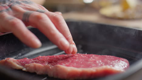 preparing beef steak on grill pan