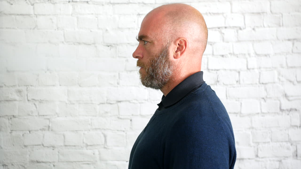 연기 구름과 함께 흰 벽 앞에서 실내에서 베이핑하는 남자의 측면 초상화