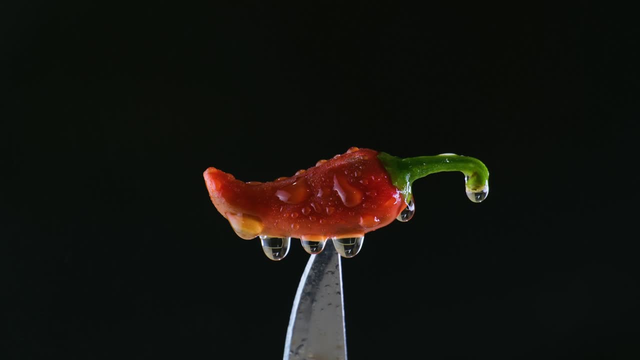 검은색 배경의 칼 위에 있는 은 칠리 위의 물 안개