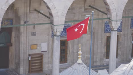 turkish flag flying over a mosque courtyard