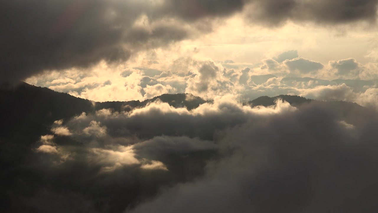 Dramatic Clouds Moving Over Mountain Peaks at Sunset