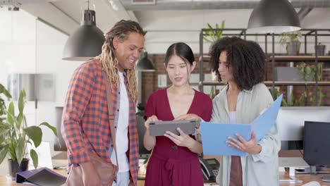 Portrait-of-happy-diverse-casual-colleagues-with-tablet-discussing-in-creative-office-in-slow-motion