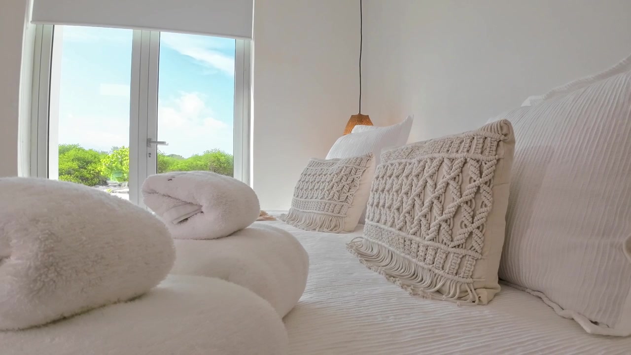 Camera da letto bianca minimalista con vista mare, arredamento moderno, trama in macramè