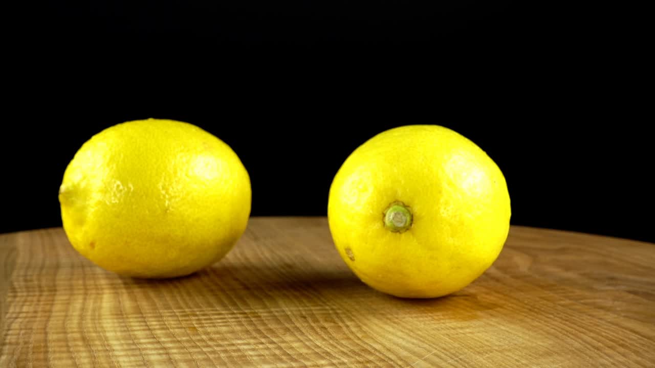Limoni su sfondo nero. Tagliere in movimento.