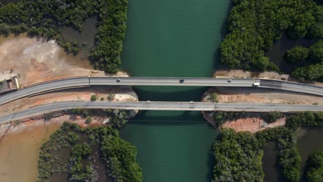 a pedestal footage as the drone moves to a higher elevation revealing two bridges with vehicles moving, the mangrove forests and this estuarine body of water, porlamar, margarita island, venezuela