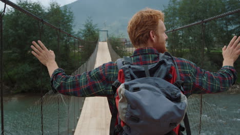 backpacker walk bridge on mountains river closeup. trekking tourist enjoy hiking