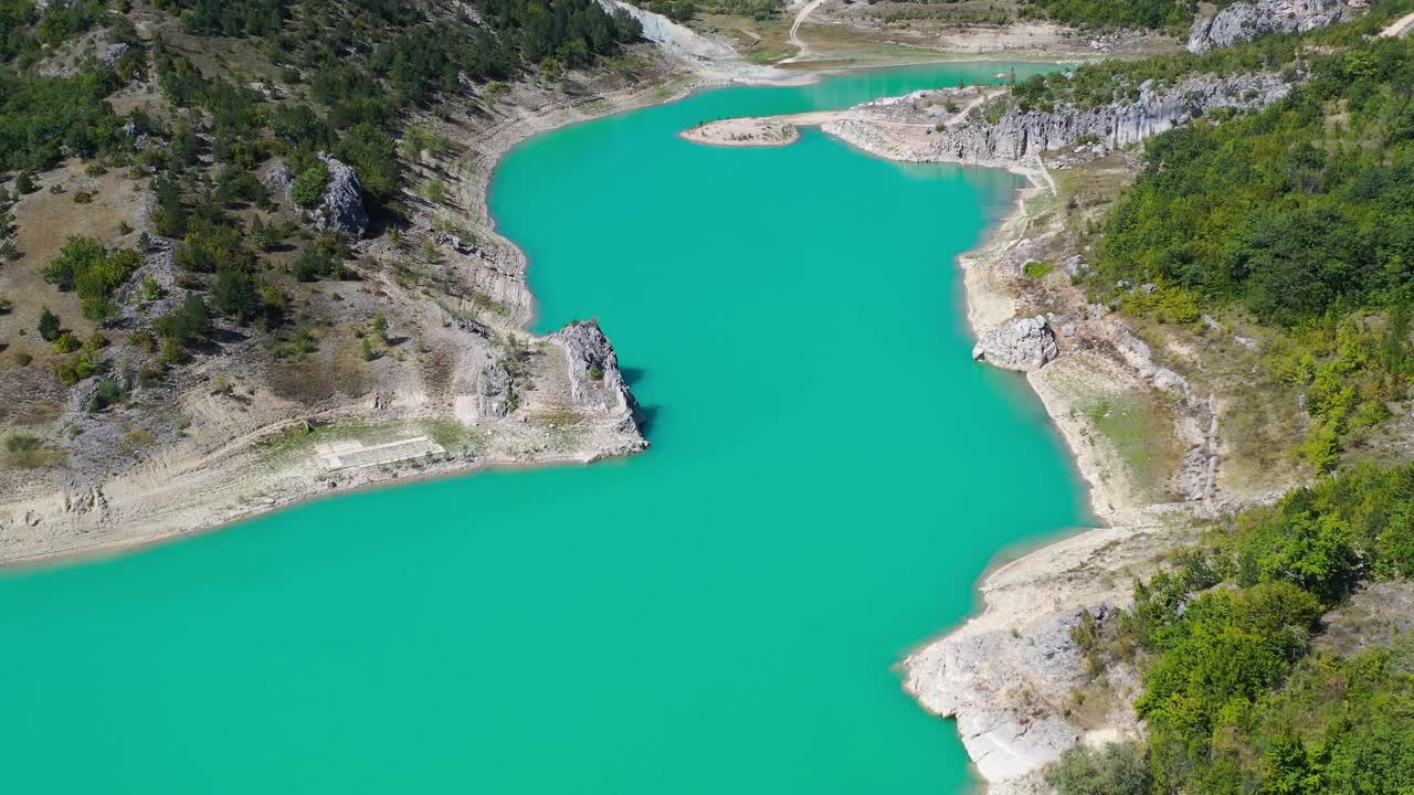 Zeleno jezero reservoir lake in Croatia with exposed shore due to low water level, Aerial dolly out shot