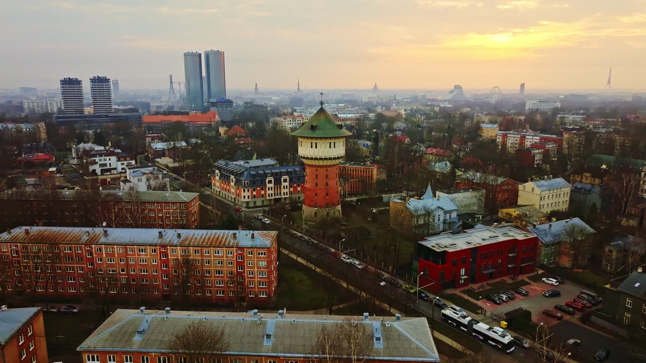 Suave slide de drone para frente ao nascer do sol sobre Riga, Letônia, com voo de pássaros