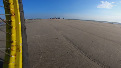 Radfahrer-Fährt-Schnell-Am-Strand-Entlang-Mit-Nahaufnahme-Eines-Gelben-Rades