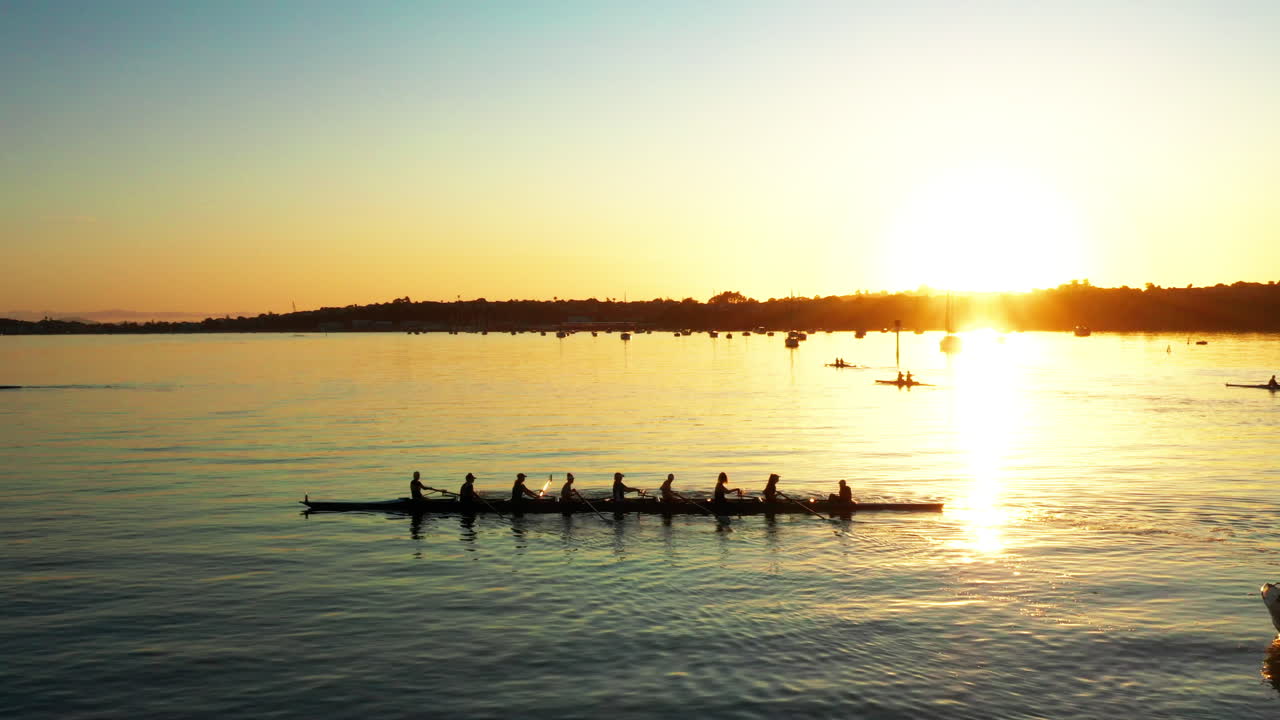 Aerial golden sunset view above Auckland port, rowing boat in forefront