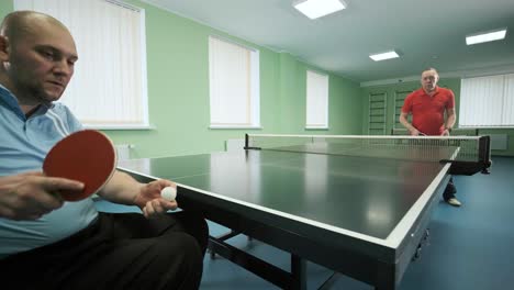 a man in a wheelchair plays ping pong. people with disabilities play table tennis. rehabilitation of the disabled. sport.