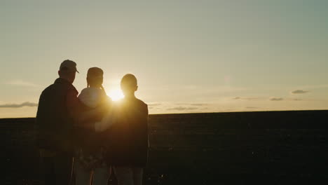 familia disfrutando de una puesta de sol en un campo