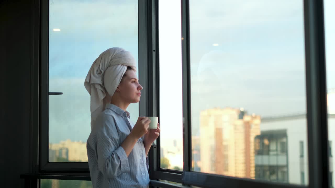 Donna che si gode un caffè e la vista della città dalla finestra