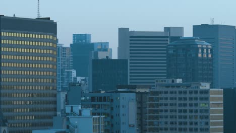 general view of cityscape with multiple modern buildings and cloudless sky