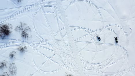 snowmobiles on snowy trails - aerial view