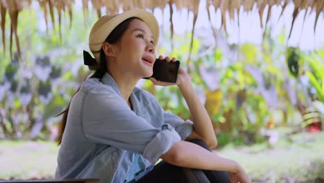 work and vacation asian female digital nomad millennial lifestyle hand hold smartphone conversation with abroad client distance meeting,asian female casual cloth walking speaking on the beach ocean