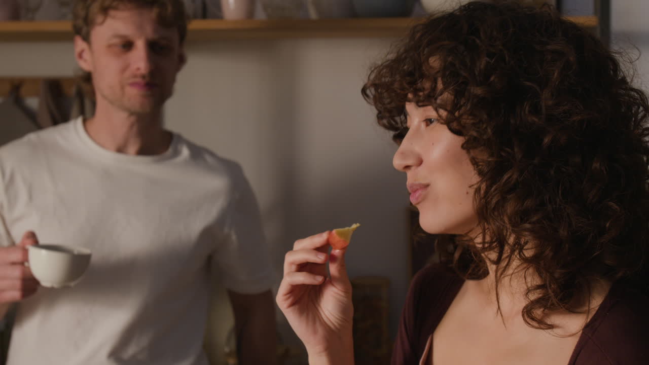 Pareja comiendo y bebiendo en la cocina