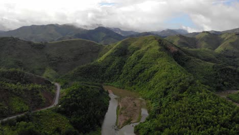 aerial dolly in over a river and a winding road at quang nam province, vietnam