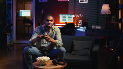 vertical video male gamer eating popcorn while he plays online shooting tournament
