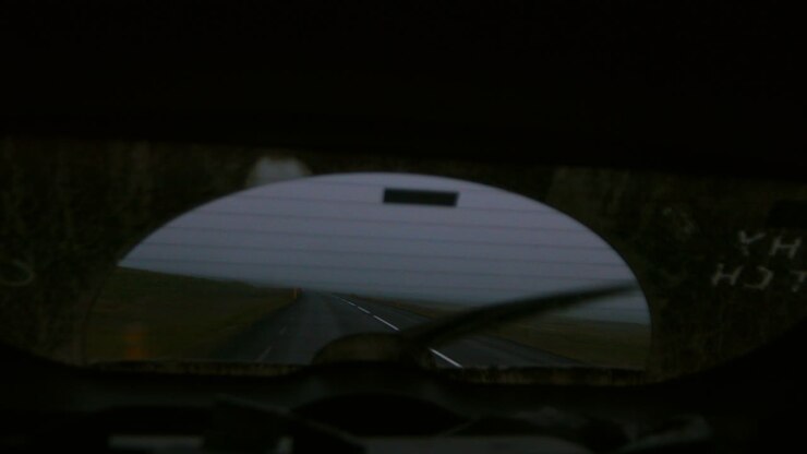 Looking out rear view window driving through storm in Iceland