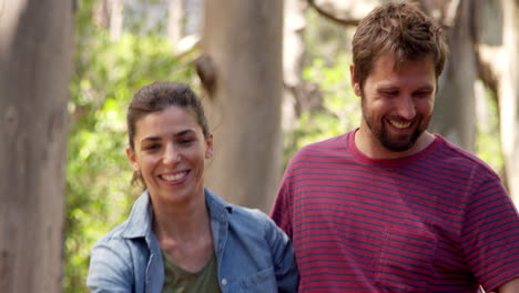 una pareja romántica caminando juntos por el camino del bosque.