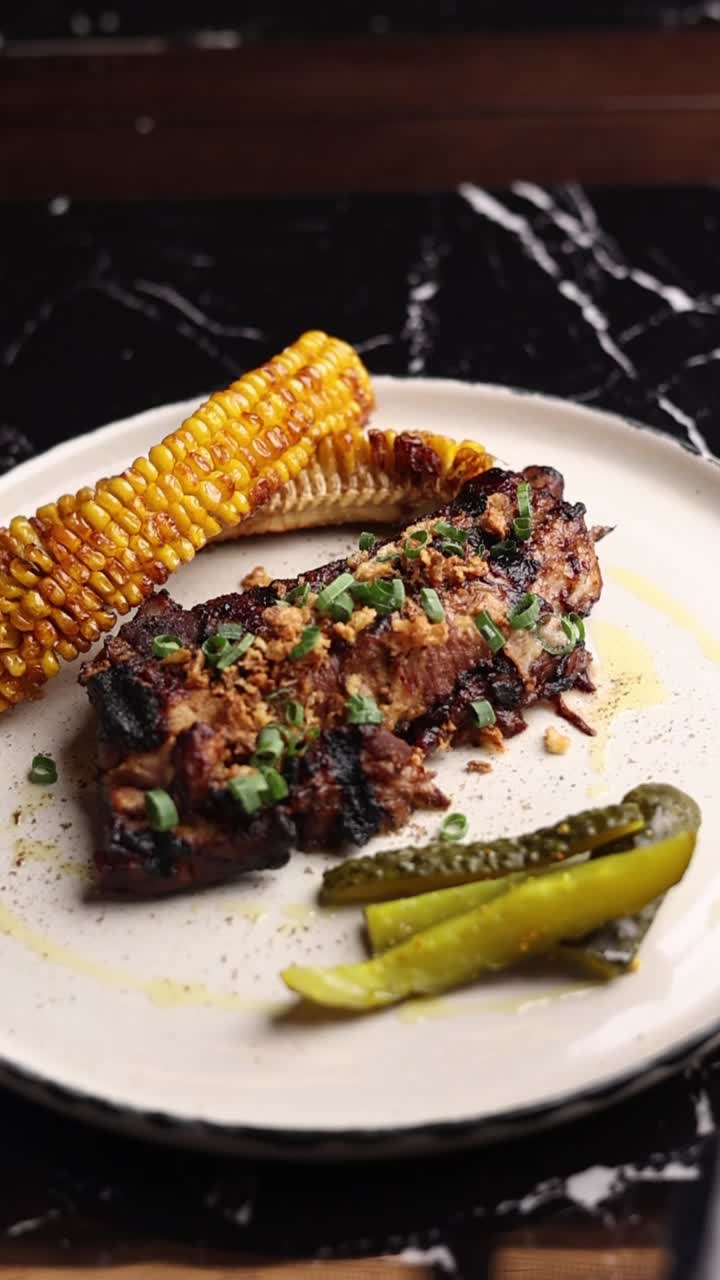 costillas de cerdo a la parrilla con maíz y pepinillos