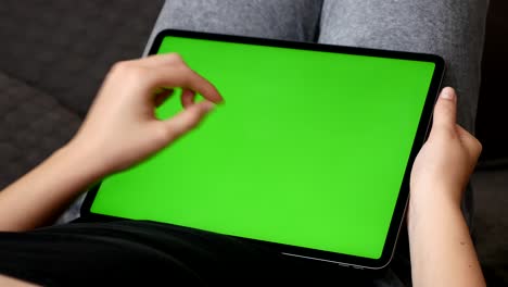 la mujer se relaja en casa con una gran pantalla verde, una tableta 4k.