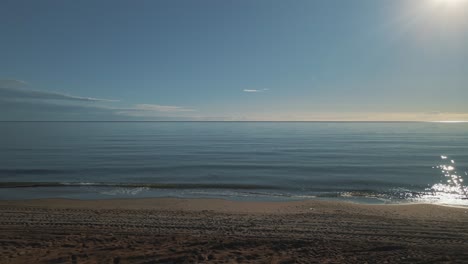 drone shot of ocean view at the beach with man standing at the shore