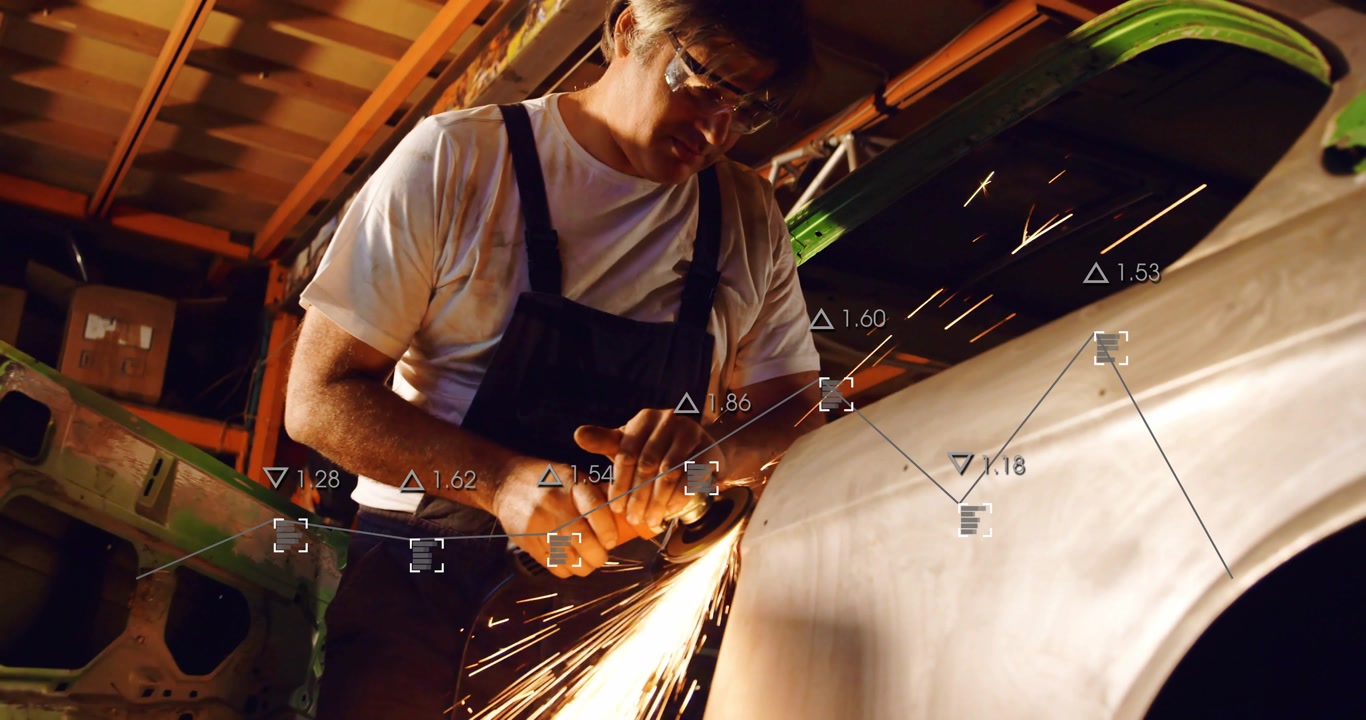 Male mechanic starting grinder against fender seam in auto workshop, sparks flying, prepping panel