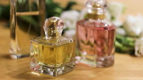 perfume bottles and flowers on a wooden table