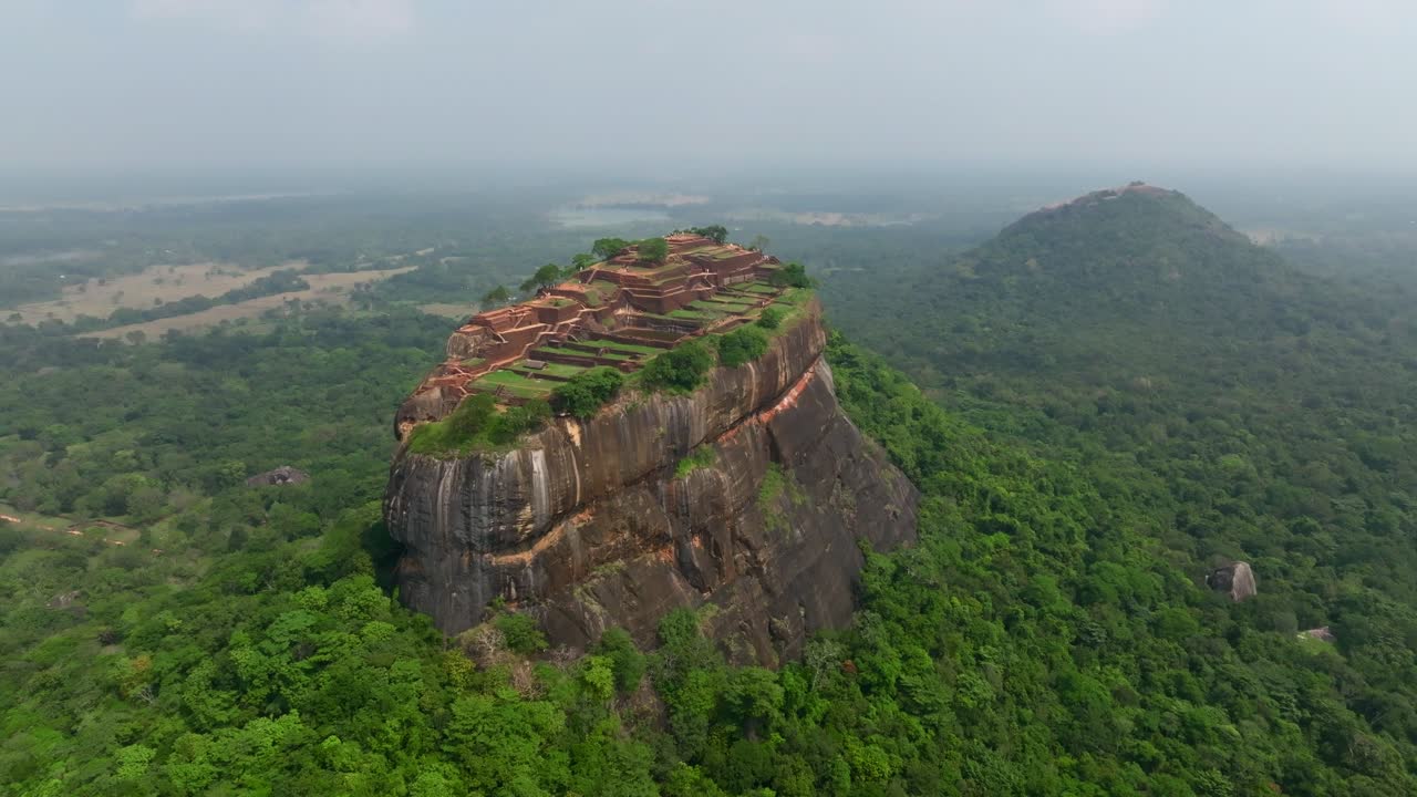 Veduta aerea dall’alto dello Sri Lanka del complesso di Sigiriya con giardino acquatico rettangolare e antiche fondamenta in mattoni sull'altopiano sommitale