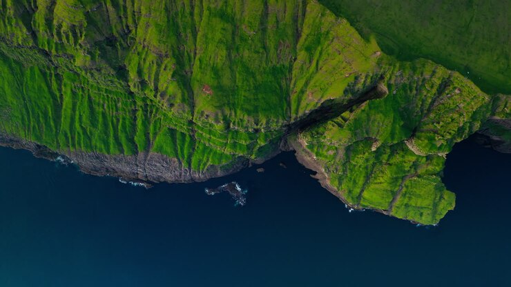 Aerial View of Dramatic Green Coastal Cliffs Meeting the Ocean