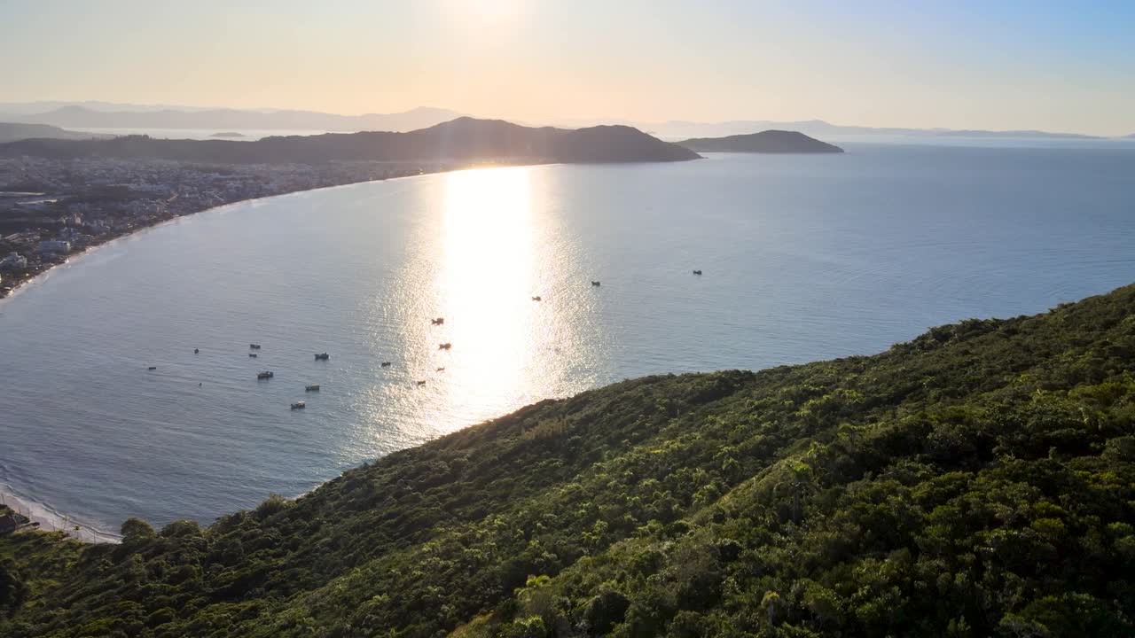 escena de drones al atardecer vista desde arriba con playa paradisíaca y montañas en florianópolis barcos de pesca en la tarde playa ingleses