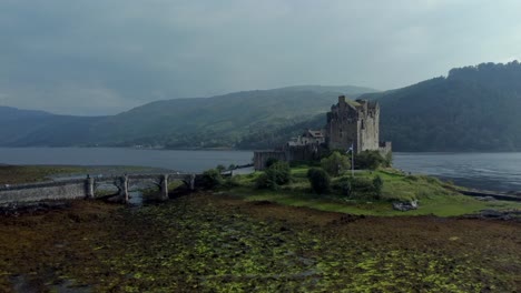 eilean donan castle in the highlands of scotland, uk _ drone shot sunset with beautiful lake rising up side