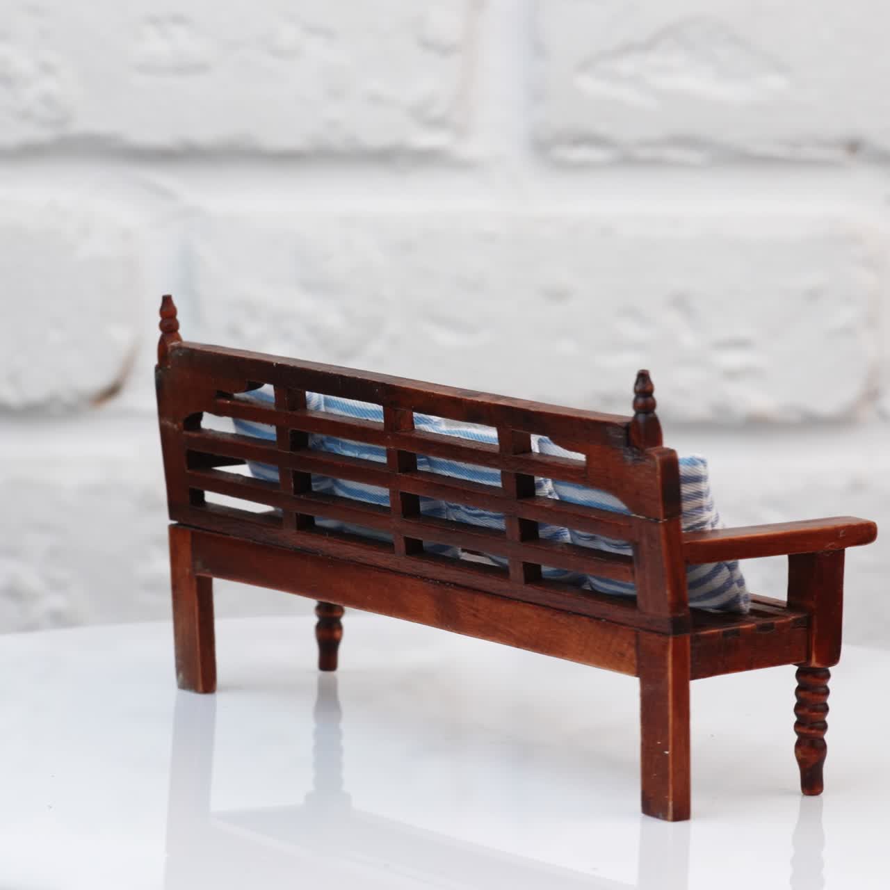 Miniature toy on wall background. Close up view of wooden toy furniture against wall background