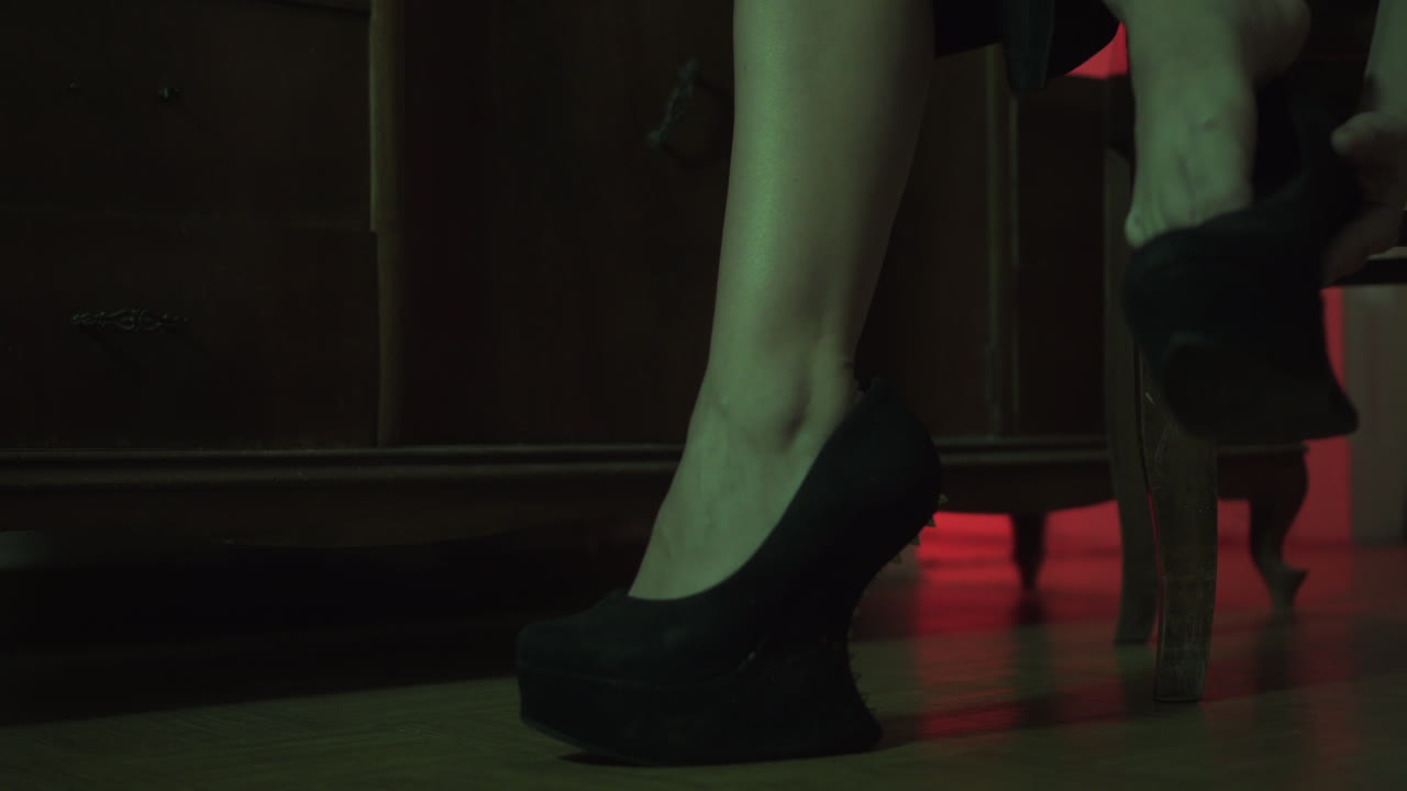 woman wear her shoes in a creepy room close up