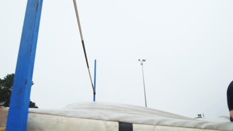 Low-angle-view-of-Caucasian-female-athlete-practicing-high-jump-at-sports-venue-4k