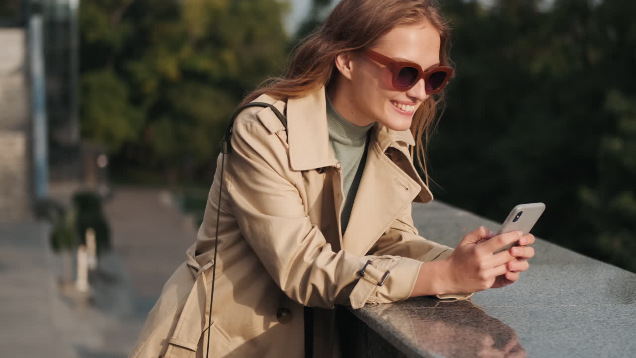 Caucasian female student using smartphone outdoors.