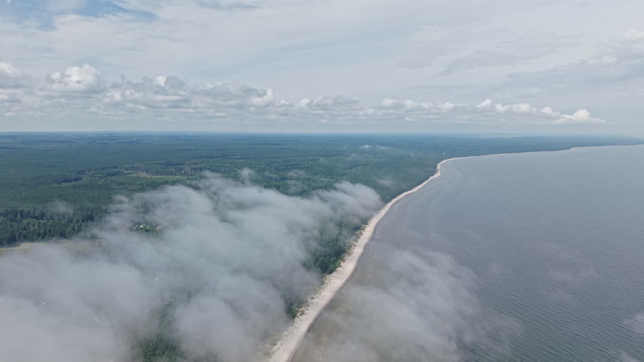 Aerial drone view of a coastline partly covered by clouds