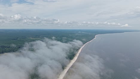aerial drone view of a coastline partly covered by clouds