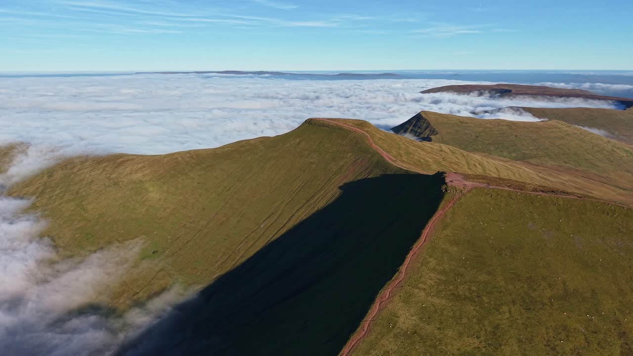 Aerial orbit of Pen y Fan and Corn Du in Wales during a cloud inversion at dusk