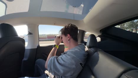 person taking pictures in a tesla car