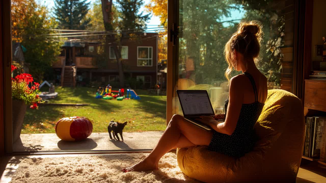 A Cozy Autumn Day: A Woman Works on Her Laptop While Enjoying the View of Her Backyard Surrounded by Colorful Leaves, Playful Children, and a Curious Cat