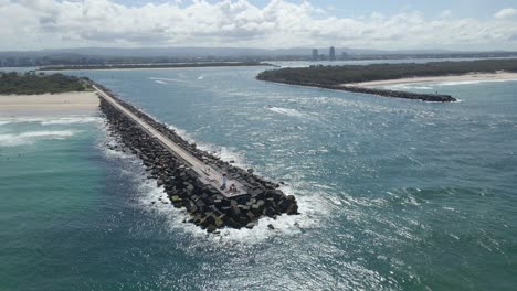 aerial view of waves crashing on the spit gold coast and nerang river in qld, australia