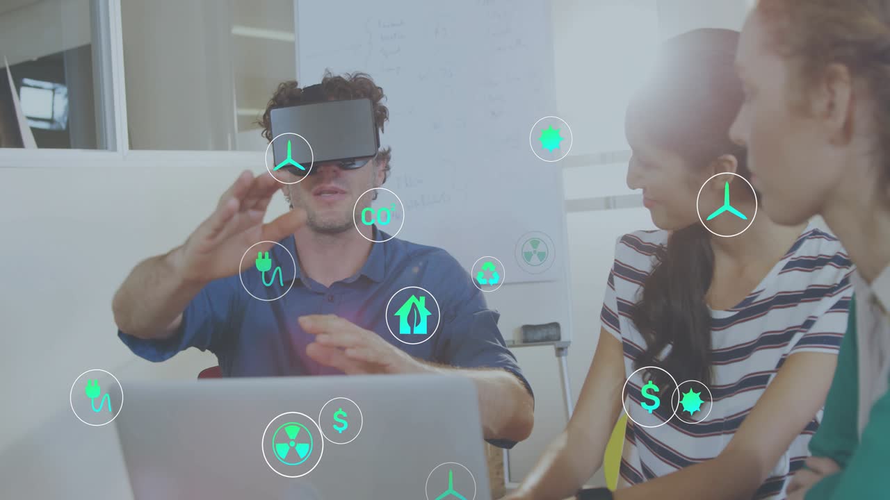 Man placing VR headset, gesturing as team viewing energy icons grouping around laptop for review