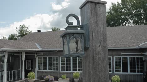 Beautiful-lantern-style-light-fixture-hanging-on-a-post-in-front-of-a-grey-wood-sided-farm-house-mansion-at-the-Strathmere-Wedding-and-Event-Centre