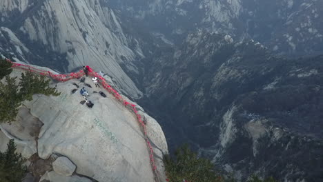 Luftaufnahmen-Zeigen-Einen-Touristen,-Der-Am-Rand-Einer-Steilen-Granitklippe-Sitzt